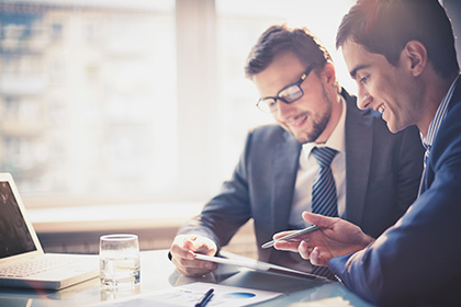 Two businessmen sitting at a desk having a discussion